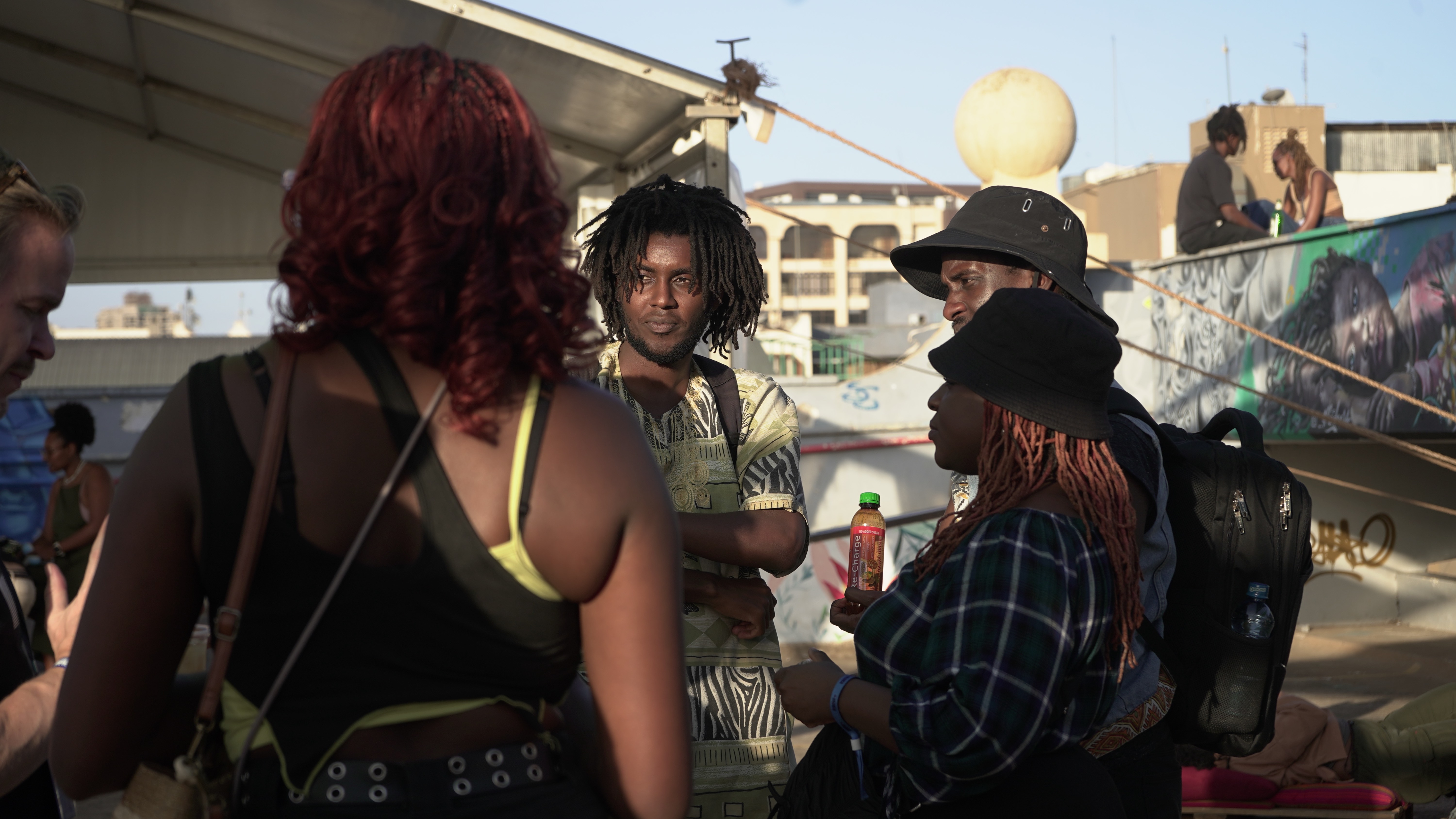 A group of Kilele participiants standing on a rooftop in the sun. 